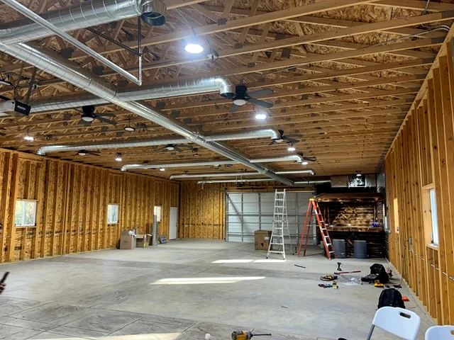 Open commercial interior with exposed HVAC ductwork and ceiling fixtures