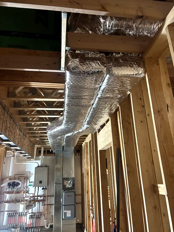Insulated HVAC ductwork installed between ceiling joists